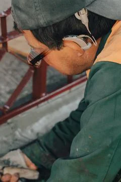 Construction technicians with hearing aid working with cement paving, mix wit Stock Photos