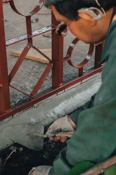 Construction technicians with hearing aid working with cement paving, mix wit Stock Photos