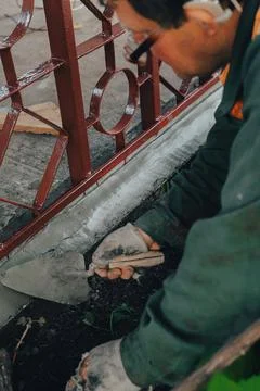 Construction technicians with hearing aid working with cement paving, mix wit Stock Photos