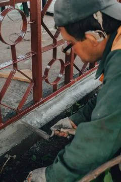 Construction technicians with hearing aid working with cement paving, mix wit Stock Photos