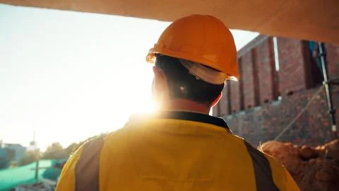 Construction, thinking and man with back on site for building progress, property Stock Photos