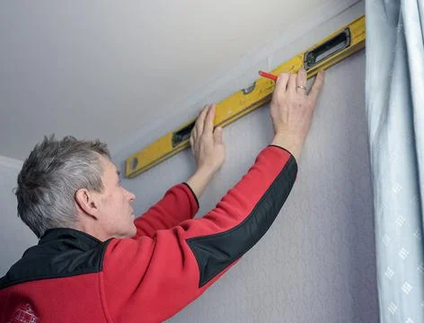 Construction tool bubble alcohol level in the hands of a man. Marking the wal Stock Photos