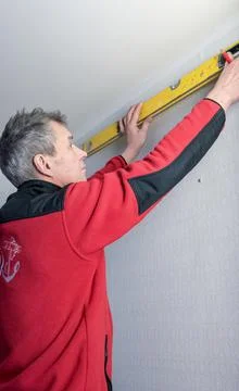 Construction tool bubble alcohol level in the hands of a man. Marking the wal Foto stock