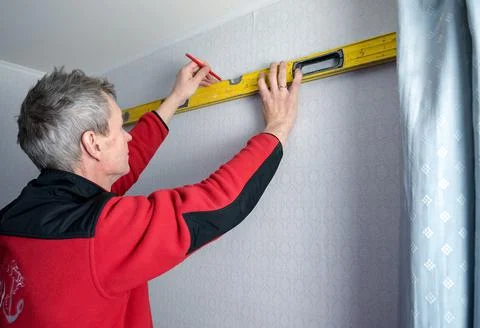 Construction tool bubble alcohol level in the hands of a man. Marking the wal Stock Photos