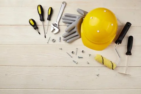 Construction tools and accessories, a yellow helmet on a white wooden backg.. 写真素材