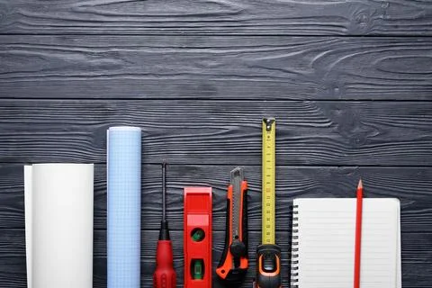 Construction tools and blueprint on dark wooden surface Stock Photos