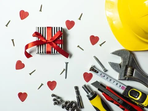 Construction tools and gift on white background with small red hearts Stock Photos