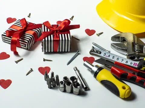 Construction tools and gifts on white background with small red hearts Stock Photos