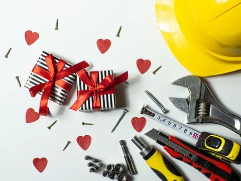 Construction tools and gifts on white background with small red hearts Stock Photos