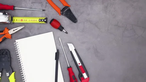 Construction tools and open notebook with pencil on dark theme. Stop motion Stock Footage 136912643
