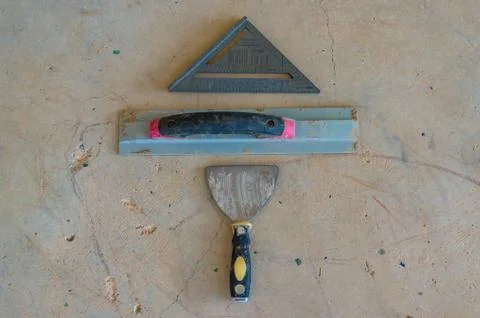 Construction tools background of palette knife, square and gauge on concrete Stock Photos