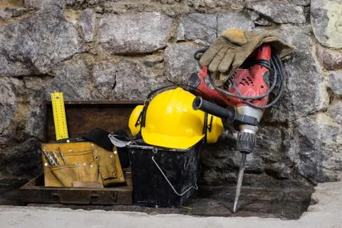 Construction tools for building a house on a stone wall. Hammer, helmet, and  스톡 사진
