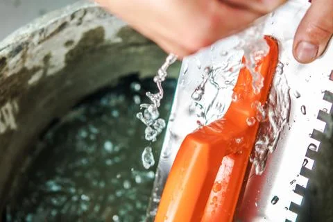 Construction Tools Cleaning Theme. Tile Trowel Washing. 库存照片