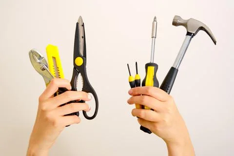 Construction tools in hands above head, closeup Stock Photos