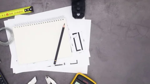 Construction tools moving around notebook and architecture plans. Stop motion Stock Footage 136917471