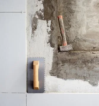 Construction tools notched trowel and hammer Foto stock