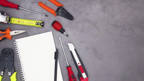 Construction tools with open notebook and pencil appear. Stop motion Stock Footage 136912614