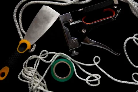 Construction tools: rope, duct tape, putty knife and a staple gun Stock Photos