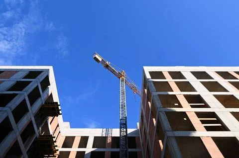 Construction tower crane between buildings detailed photo Stock Photos