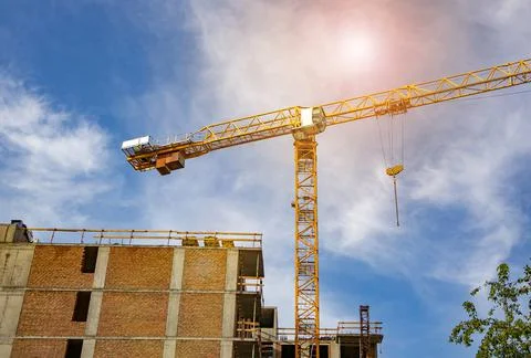 Construction tower crane on the construction site of a modern brick residenti Stock Photos