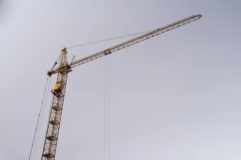 Construction tower crane on gray sky background Фото