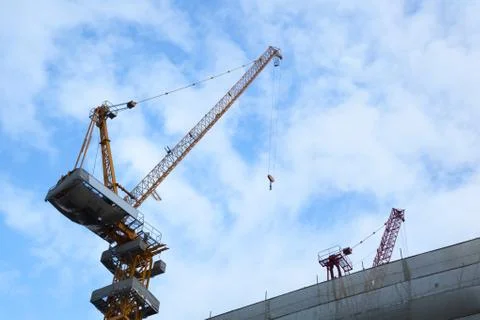 Construction tower cranes building on  empty blue sky background. Constructio Stock Photos