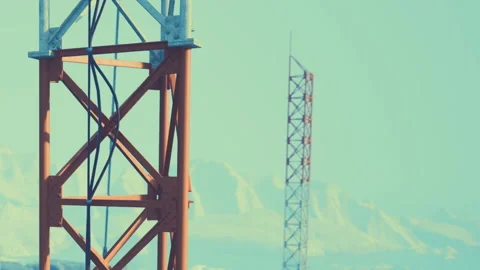 Construction tower stands against mountain backdrop in daylight Stock Footage 344297759