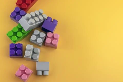 Construction toy plastic figures and bricks on a yellow background. Colorful Stock Photos