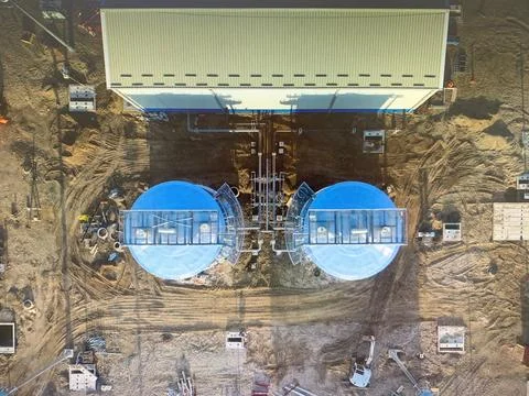 The construction of two large blue storage fluid tanks on an industrial site Stock Photos