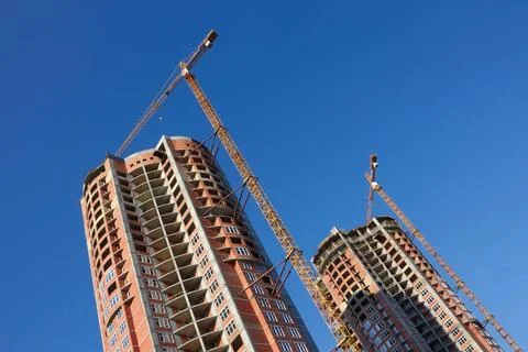 Construction of two parallel skyscrapers Building cranes on the constructi... 库存照片
