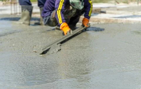 Construction under the building with mason plastering concrete to a cement. Stock Photos