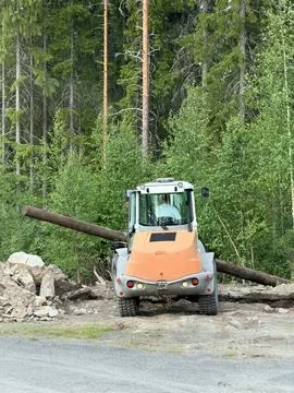 Construction vehicle with long timber in a forest clearing Photos