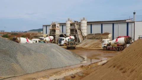 The construction vehicles in the concrete batch plant are busy working to make Stock Footage 130885503