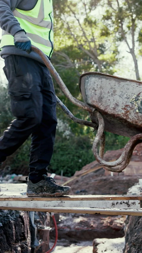 Construction, walking and man with wheelbarrow outdoor for materials, tools and Stock Footage 340451303