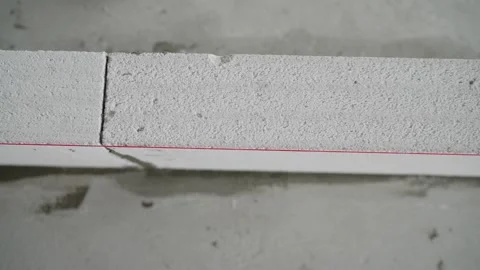 Construction of a wall from white blocks. Aligning the wall along the cord Stock Footage 249876542