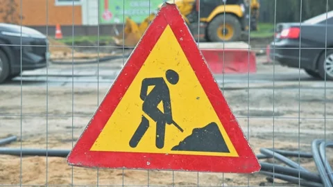 A construction warning sign is placed in a work zone, signaling upcoming Видео 344675709
