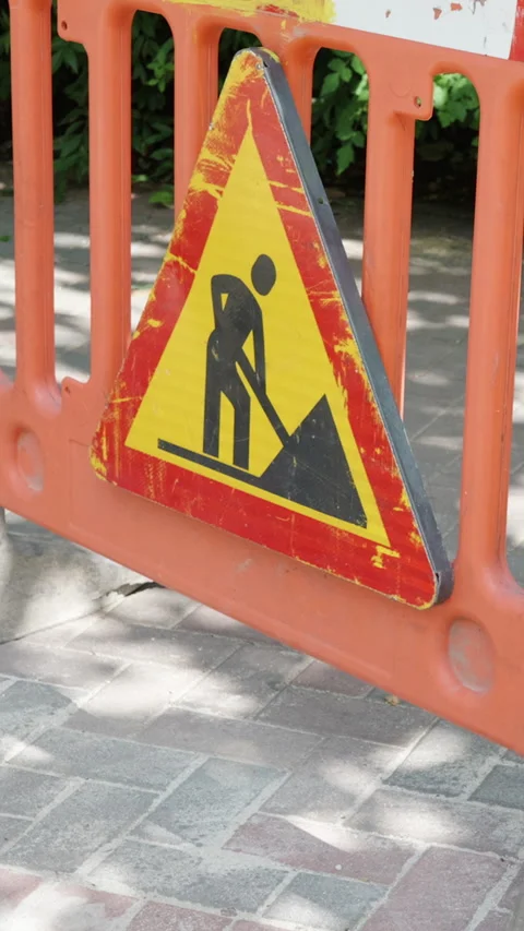 Construction warning sign with worker icon and shovel, displayed on orange Stock Footage 341438196