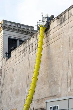 Construction waste chute attached to the facade of an old building Stock Photos