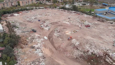 Construction waste dump, aerial view. Bulldozer pushes trash one heap. Garbage Stock Footage 141292173