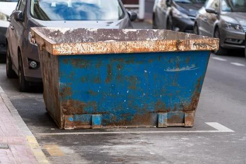 Construction waste dumpster container on urban street 스톡 사진