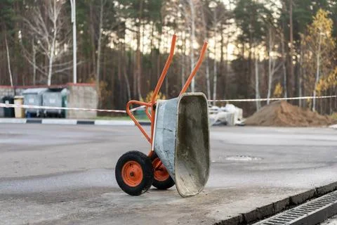 Construction wheelbarrow on an empty construction site, construction and Stock Photos