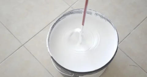 Construction whisk stirs white paint in bucket. Home repair Stock Footage 290169005