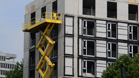 Construction wokers using giant scissor lift on site leeds uk Stock Footage 91569834