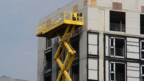 Construction wokers using giant scissor lift on site  leeds uk Stock Footage 91569838