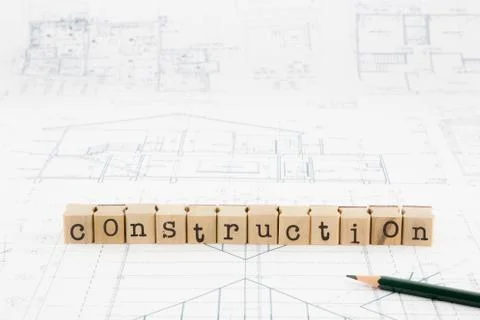 Construction word blocks stack on blueprints and floor plan Stock Photos