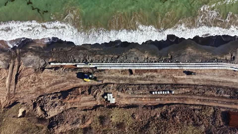 Construction work along the shoreline near the beach with heavy machinery and Stock Footage 336552824