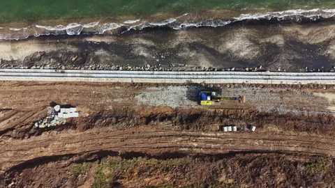 Construction work on beach area with machinery and materials on site during Stock Footage 336542370