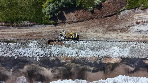 Construction work on beach road near the shore showing heavy machinery and a Stock Footage 337917512