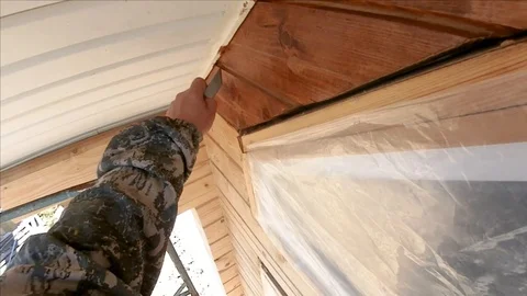 Construction work with a brush in a house built of wood Stock Footage 103154886