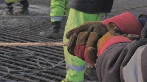 Construction work, a builder in red gloves pulls a cable Stock Footage 300871490